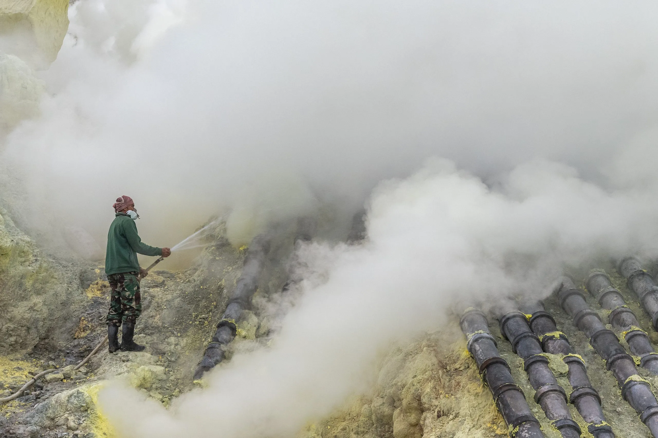 A miner cools the pipes with water, steam and smoke swallowing him