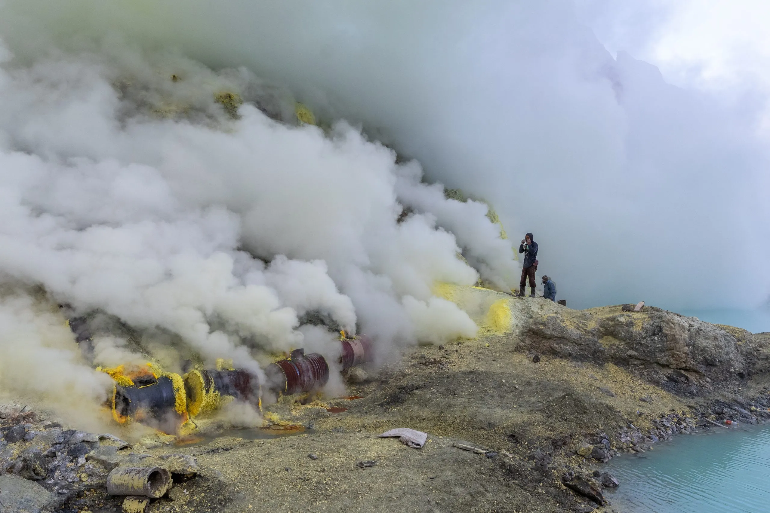 Sulfur smoke pours over the crater slope while the work goes on