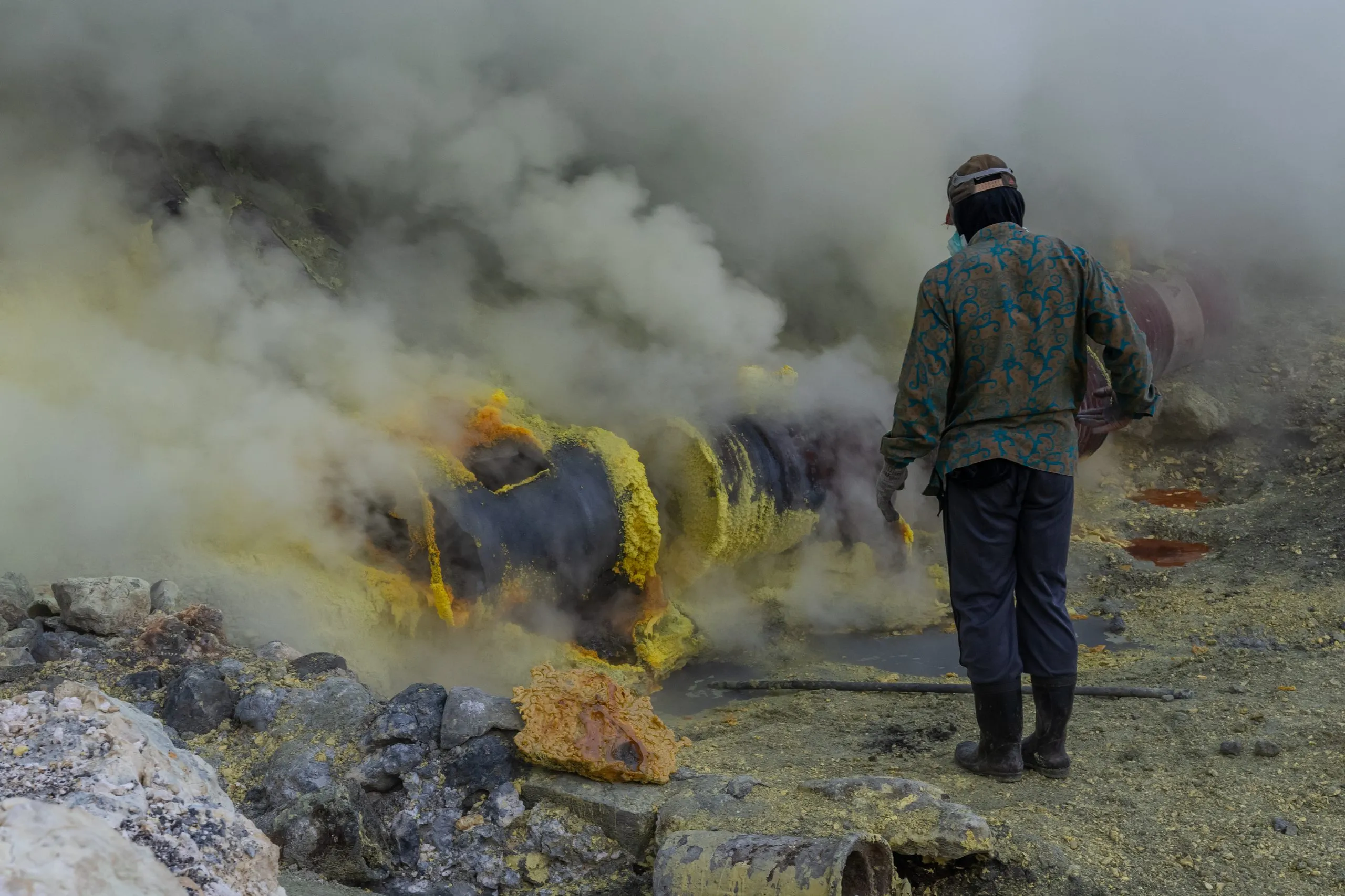 A miner beside the sulfur-crusted kiln