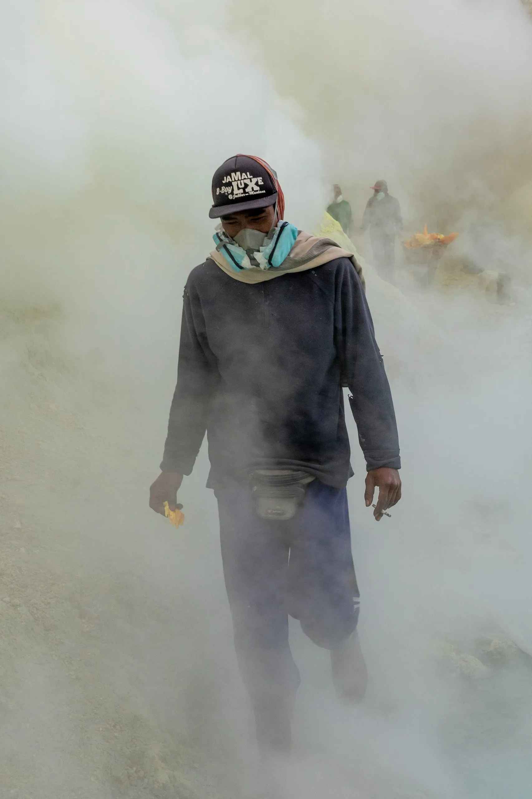 A miner walks through the white-out, scarf pressed to his face
