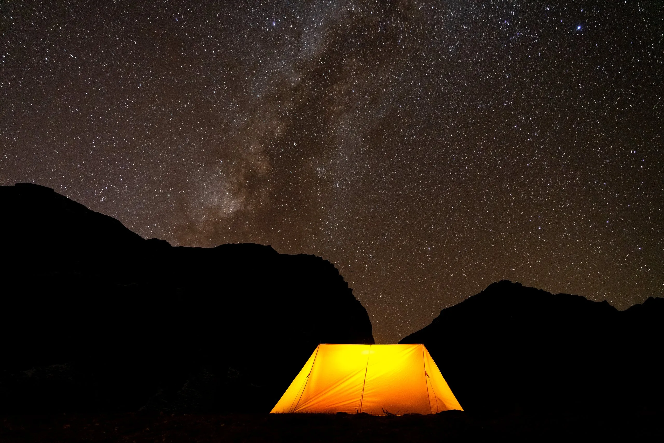 A tent glowing under the Milky Way